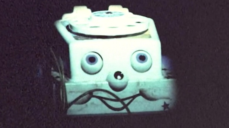Creepy rotary phone toy with a face