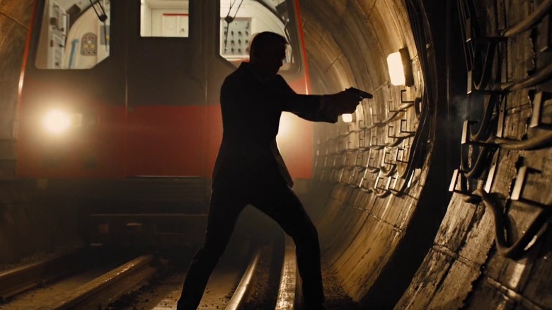 The silhouette of James Bond aims a gun in front of a train