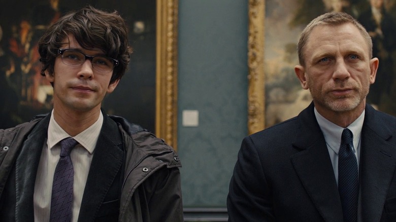 Q and Bond sit in an art gallery