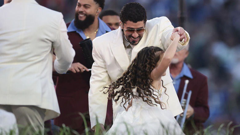 Bad Bunny dances with a girl during the reception portion of his halftime show