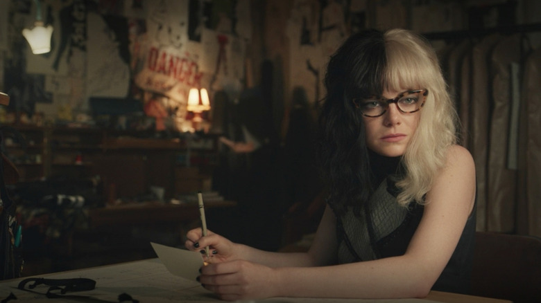 Cruella wearing glasses in her studio