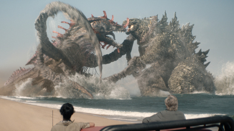 Lee Shaw and Kieko Randa watching Godzilla battling Titan X on a beach in Monarch: Legacy of Monsters Season 2 (2026)