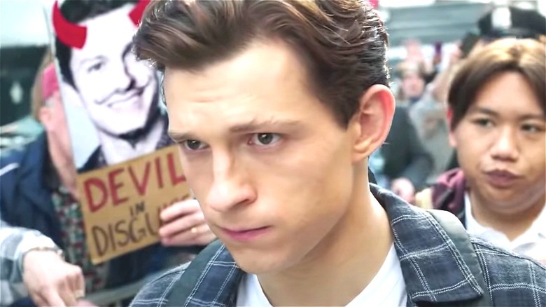 Peter Parker walking past devil poster