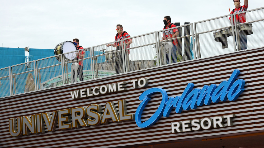 sign for Universal Orlando Resort; performers in masks