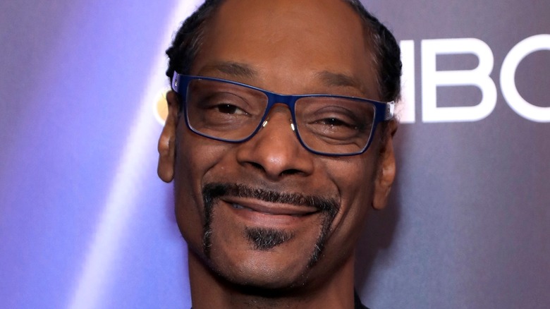 Snoop Dogg smiles at an event
