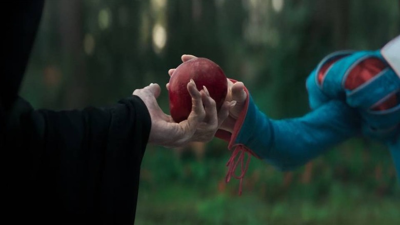 Evil Queen handing Snow White an apple
