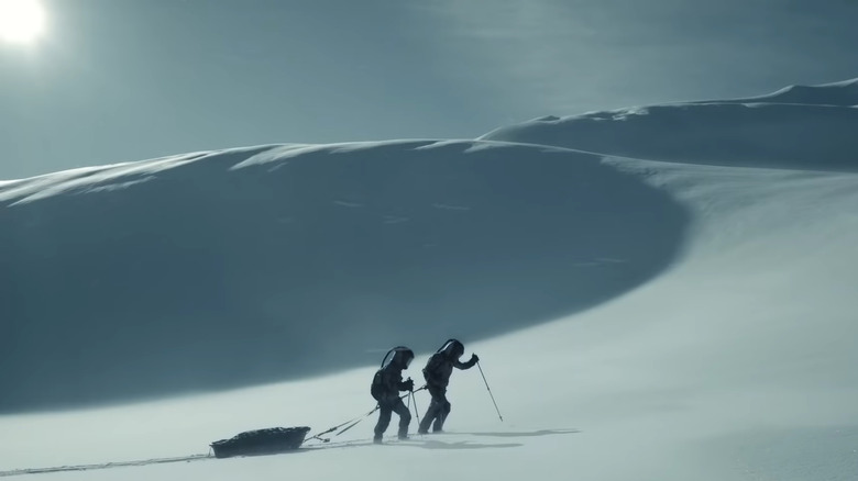 Two figures walk across a snowscape in Snowpiercer
