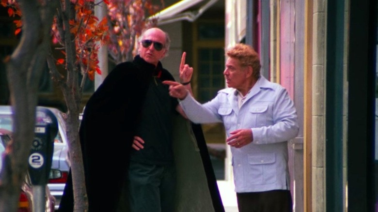 Costanza senior and caped lawyer on street