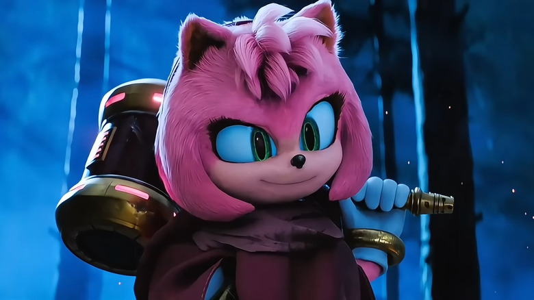 Amy Rose smirking at Sonic while hoisting her Piko Piko Hammer on her shoulder, wearing a cloak, in the mid-credits scene of "Sonic the Hedgehog 3"