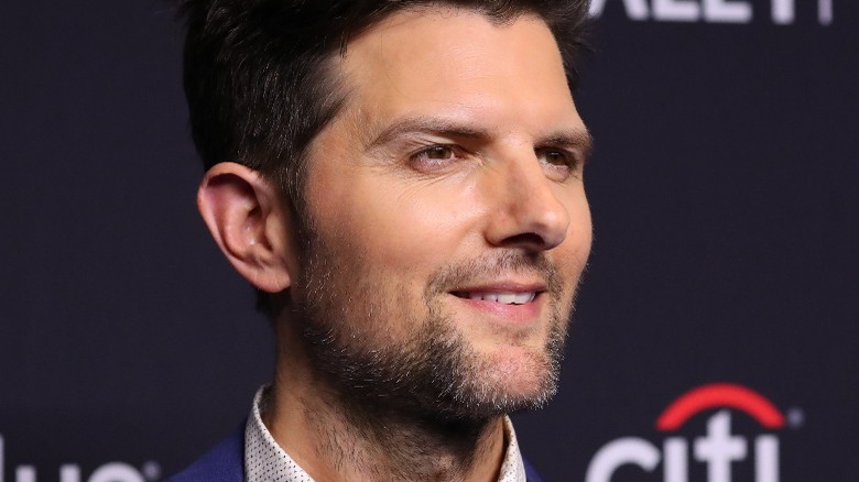 Adam Scott posing for pictures on a red carpet