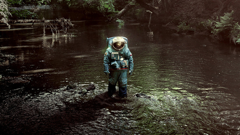 Jakub Procházka wading through river