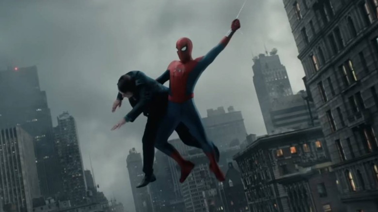 Spider-Man swinging while carrying a guy in 