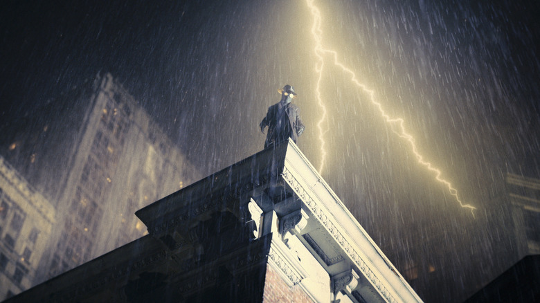 The Spider stands atop a building with lighting in the background in "Spider-Noir"