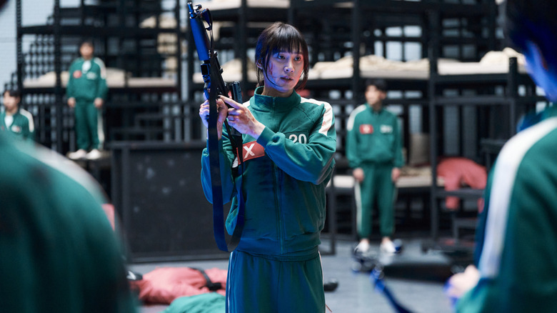 Hyun-ju wieling a gun in the player dorms in Squid Game