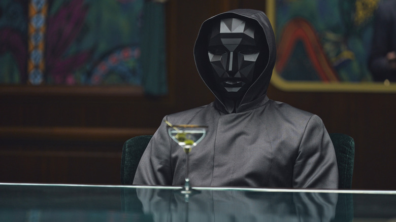 The Front Man wearing a mask with a martini in front of him on Squid Game (2025)