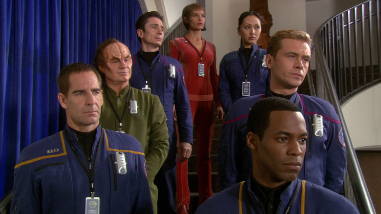 Jonathan Archer, Phlox, Malcolm Reed, T'Pol, Hoshi Sato, Trip Tucker, and Travis Mayweather standing on a staircase on Star Trek: Enterprise