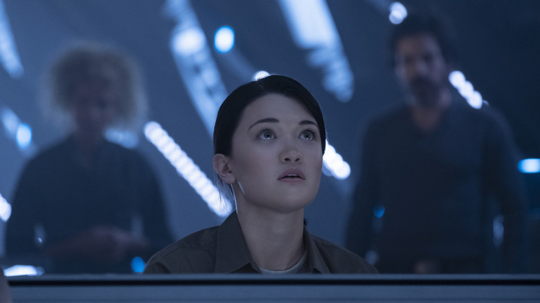 Soji looks up with Raffi and Chris blurry in the background in Star Trek: Picard (2020)