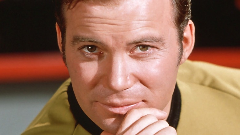 Captain Kirk smiling with hand on his chin