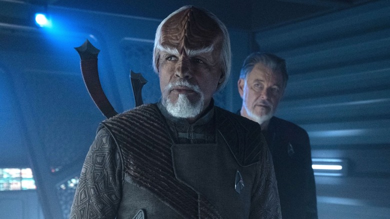 Riker standing behind Worf