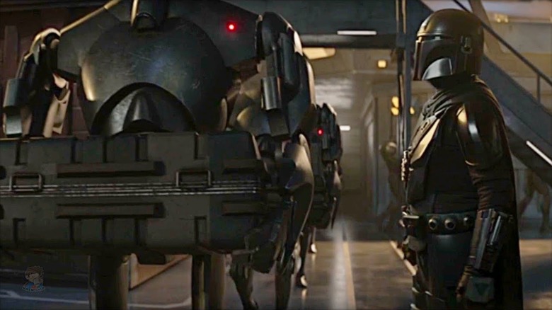 Din Djarin staring derogatorily at a group of B2 battle droids in The Mandalorian (2023)