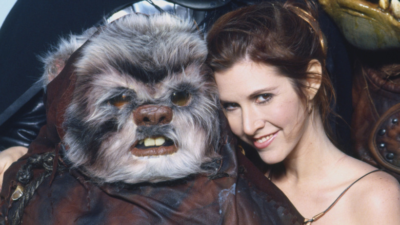 Carrie Fisher poses with an Ewok