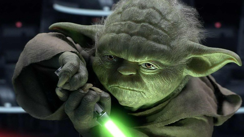 Yoda holding green lightsaber
