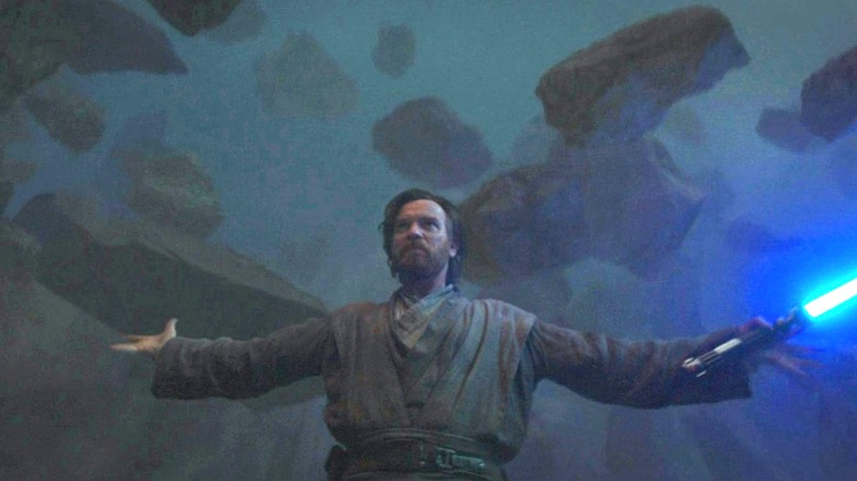 Obi-Wan Kenobi lifting boulders with his lightsaber ignited in "Obi-Wan Kenobi"