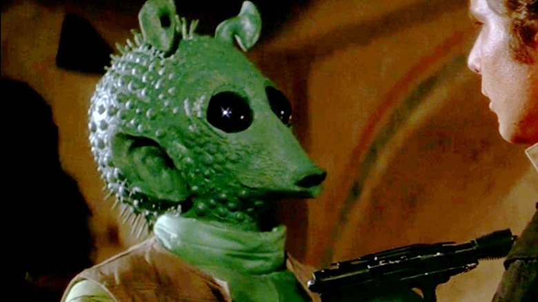 Greedo pointing his blaster at Han Solo