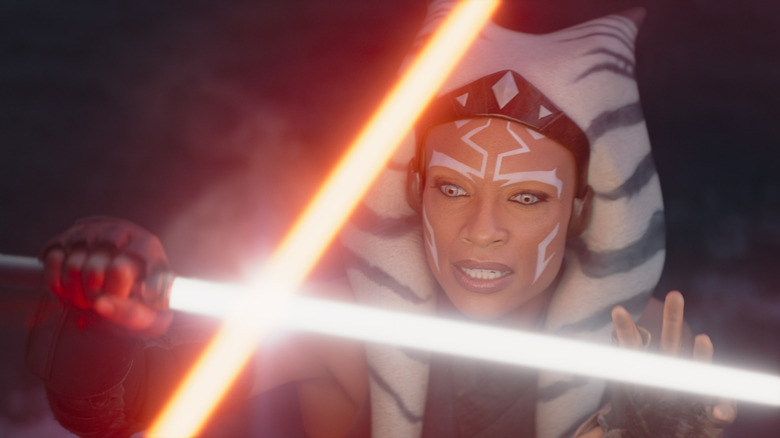 Ahsoka holding back a red lightsaber with her white lightsaber in 