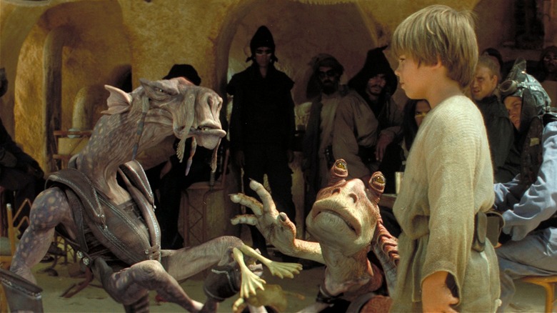 Sebulba, Jar Jar, and young Anakin talking outside in 