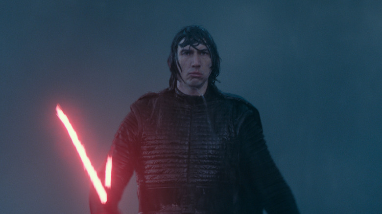 A very wet Kylo Ren walking through the rain with his red lightsaber ignited in Star Wars: Episode IX -- The Rise of Skywalker (2019)