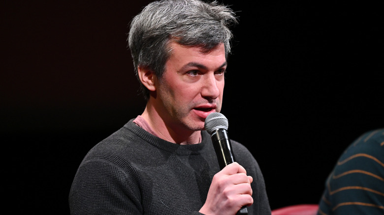 Nathan Fielder holds a mic