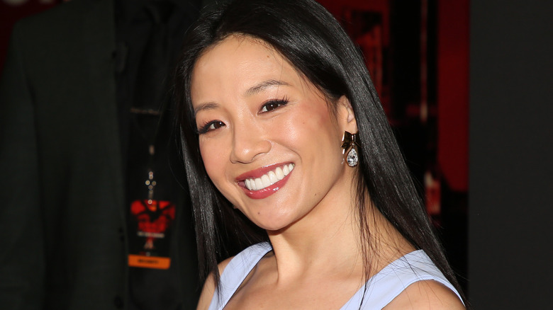 Constance Wu smiling in a blue dress