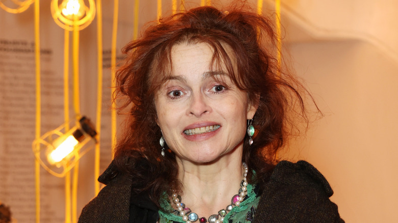 Helena Bonham Carter smiling in front of yellow lightbulbs