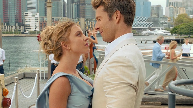 Bea and Ben pressed against each other outside in formal clothes in Anyone but You (2023)