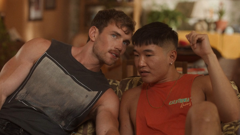 Charlie discretely telling Noah something in Fire Island (2022)