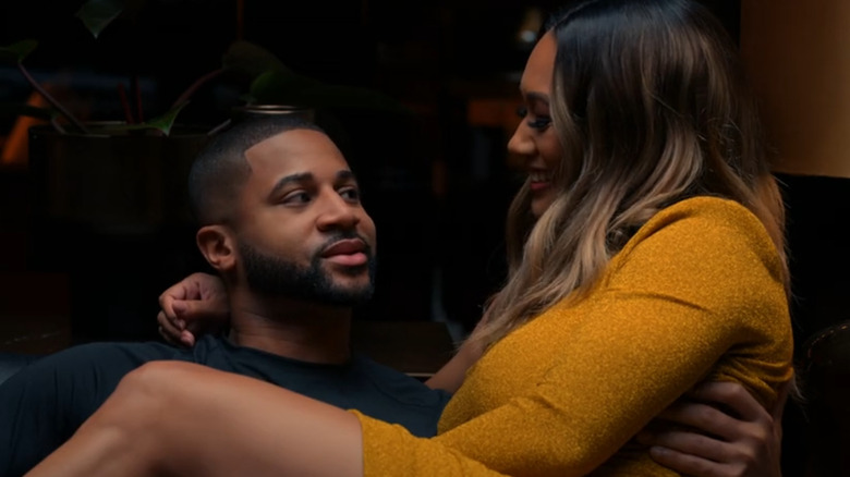 Fatima smiles as she sits in Zac's lap in Zatima (2022)