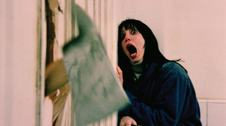 Wendy Torrance screams in horror as an axe plunges through the door in "The Shining" (1980)