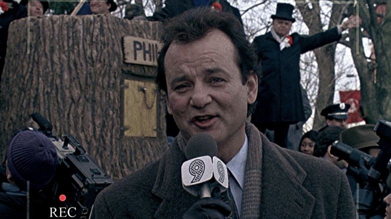 Phil speaking into a microphone on the news in "Groundhog Day"