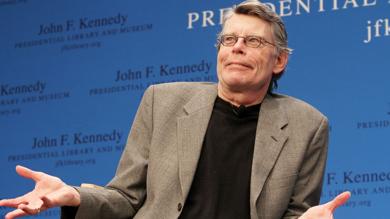 Stephen King holding his hands up, looking bemused