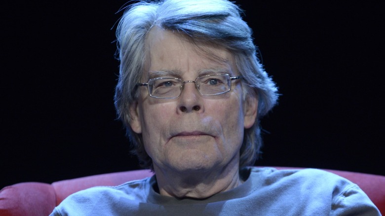 Stephen King seated in a red chair on a stage