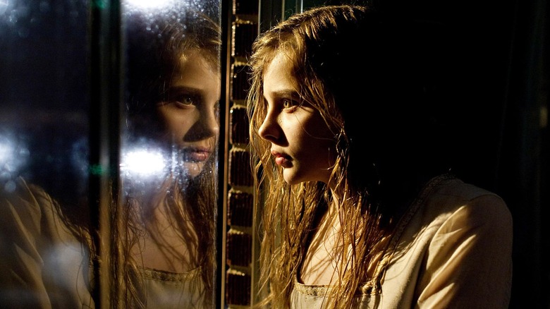 Abby stares through her reflection in Let Me In