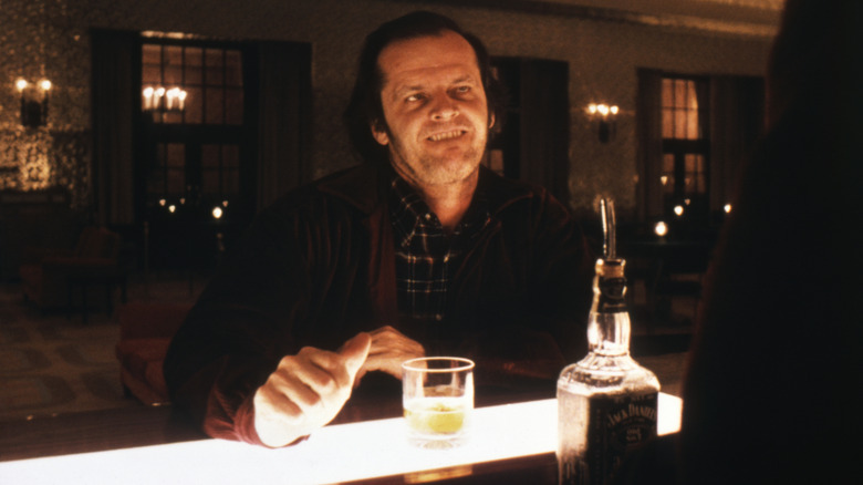 Jack sitting at a bar biting his lip in "The Shining"