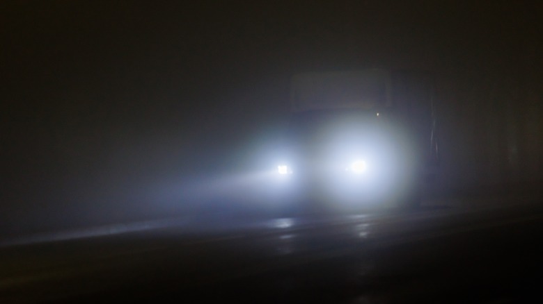 Headlights of a scary van on a dark road