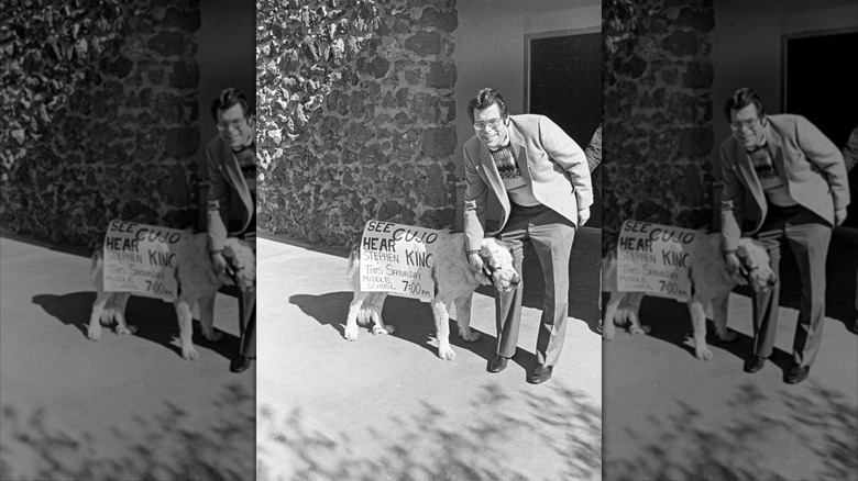 Stephen King with a dog who is wearing a sign that says See Cujo, Hear King