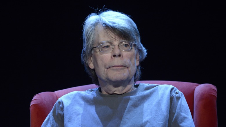 Stephen King sitting in red chair