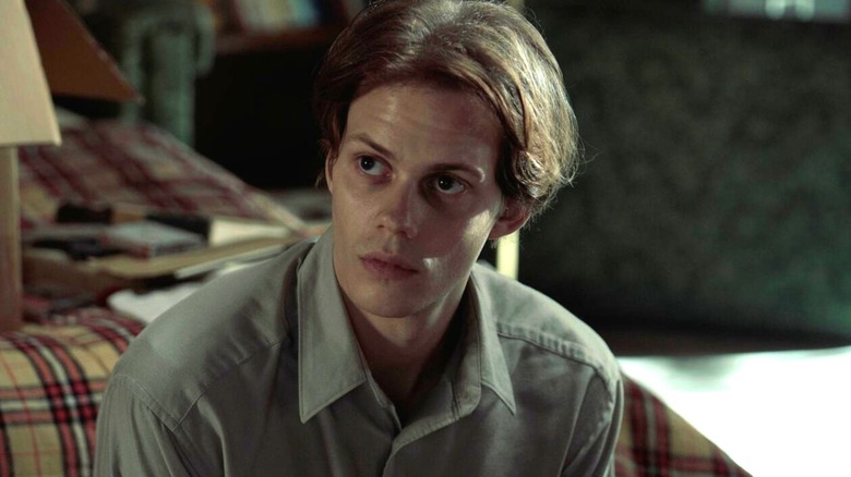 The inmate sitting on a bed in 