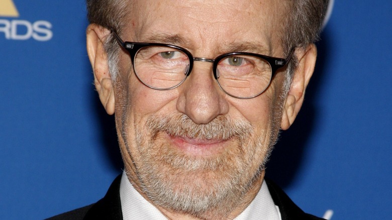 Steven Spielberg wearing glasses smiling on red carpet