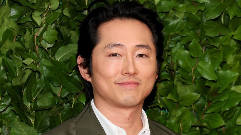 Steven Yeun smirking