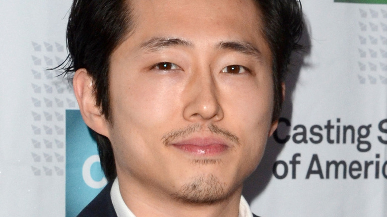 Steven Yeun smiling on red carpet